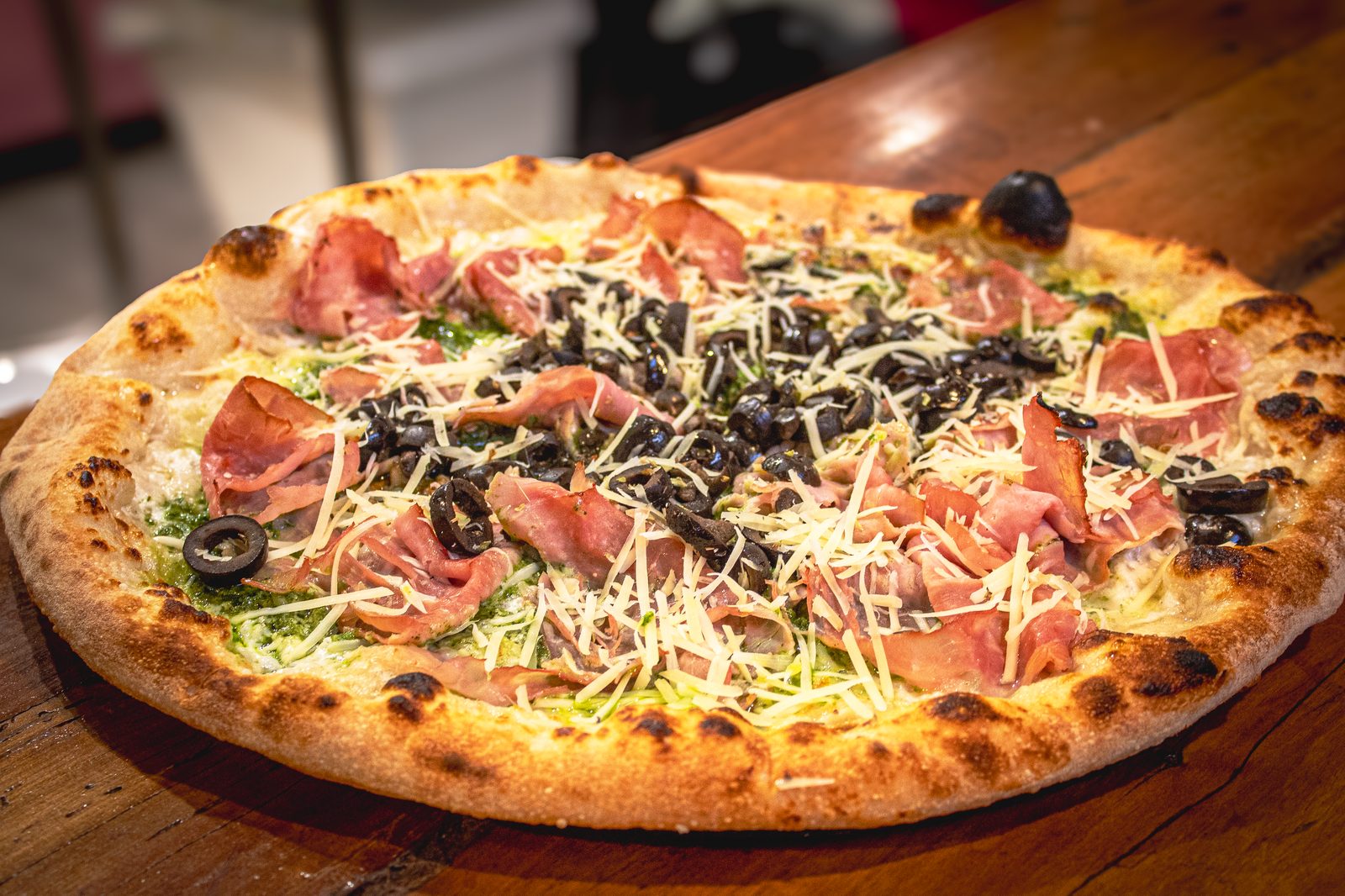 Pizza Nicolassa real — pesto, jamón, aceitunas negras y queso